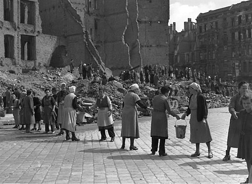 9th July 1945:  Women in post-war Berlin, East Germany, form a ‘chain gang’ to pass pails of rubble to a rubble dump, to clear bombed areas in the Russian sector of the city.